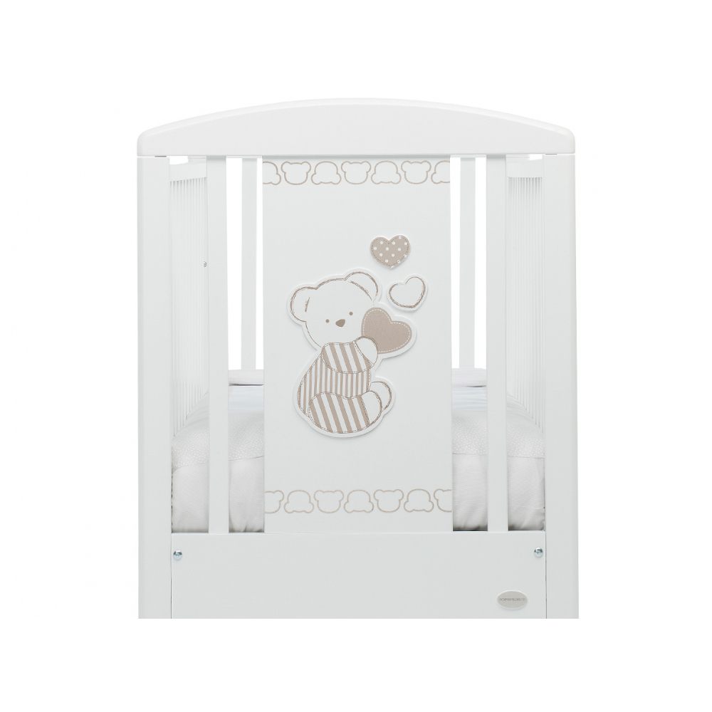 La testate del lettino bianco ha decorazioni con teneri cuori e un dolcissimo orsetto